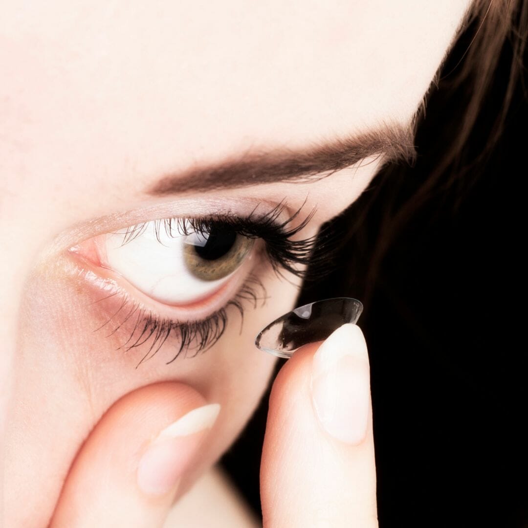 Young lady putting in her contact lens